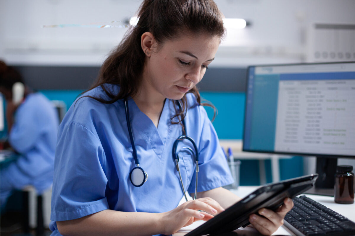 Nurse checking patient data on tablet