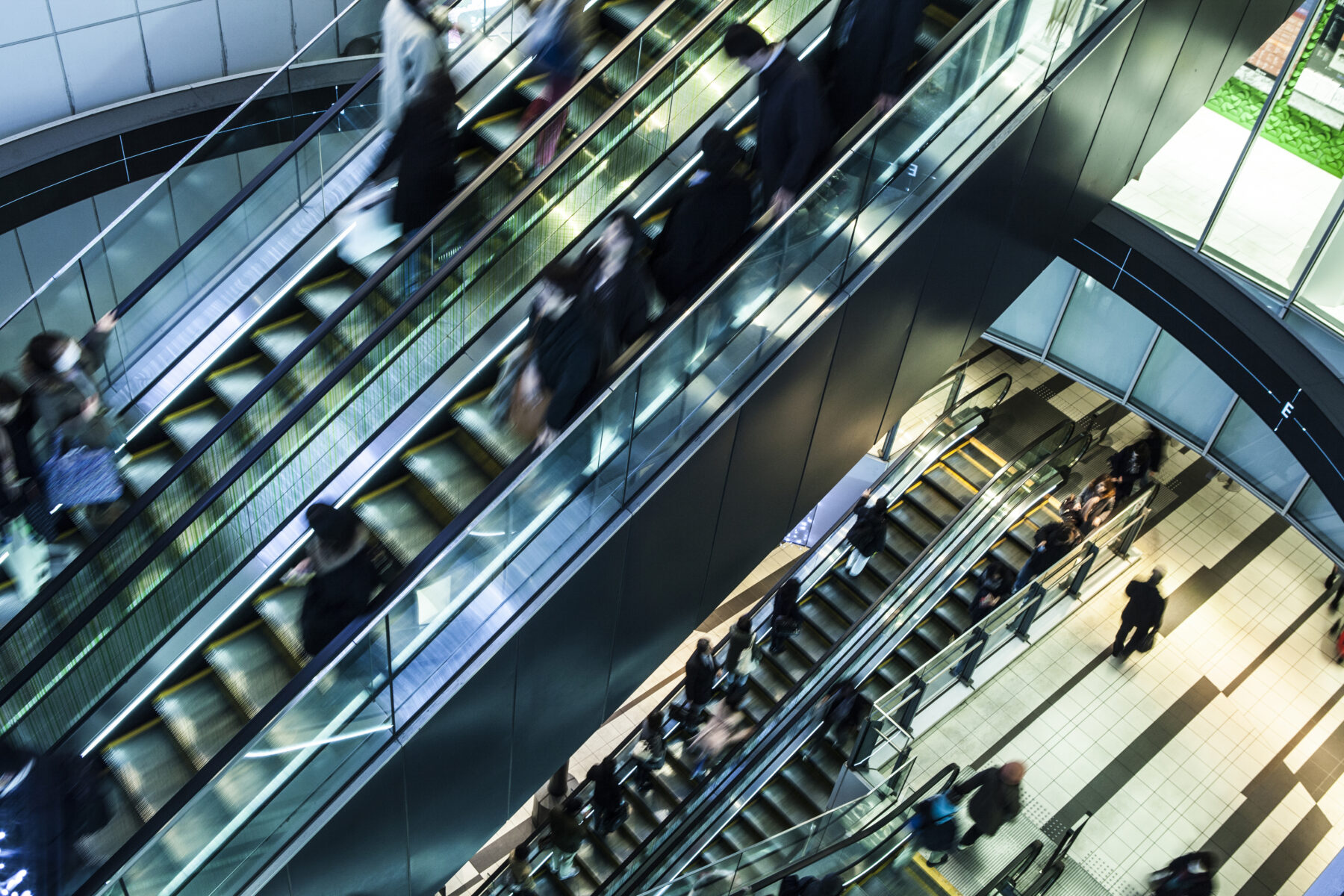 People on escalators in a building