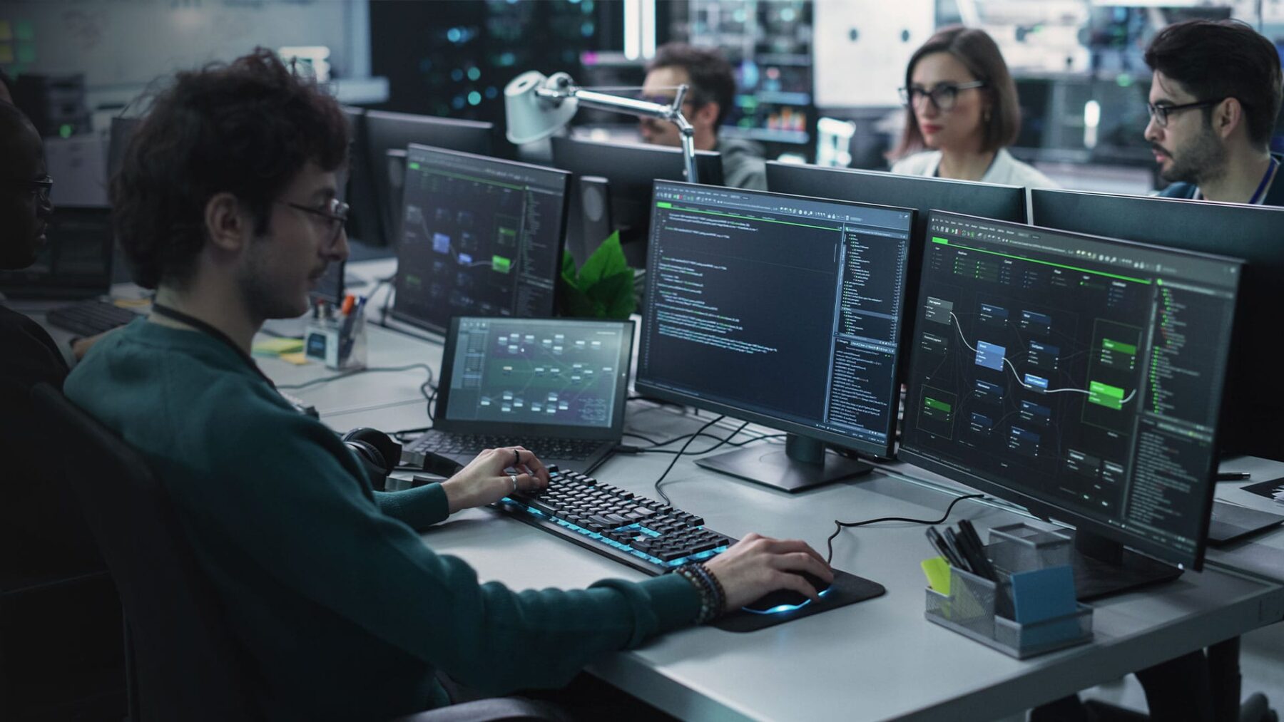 Researcher at desk with data on screens