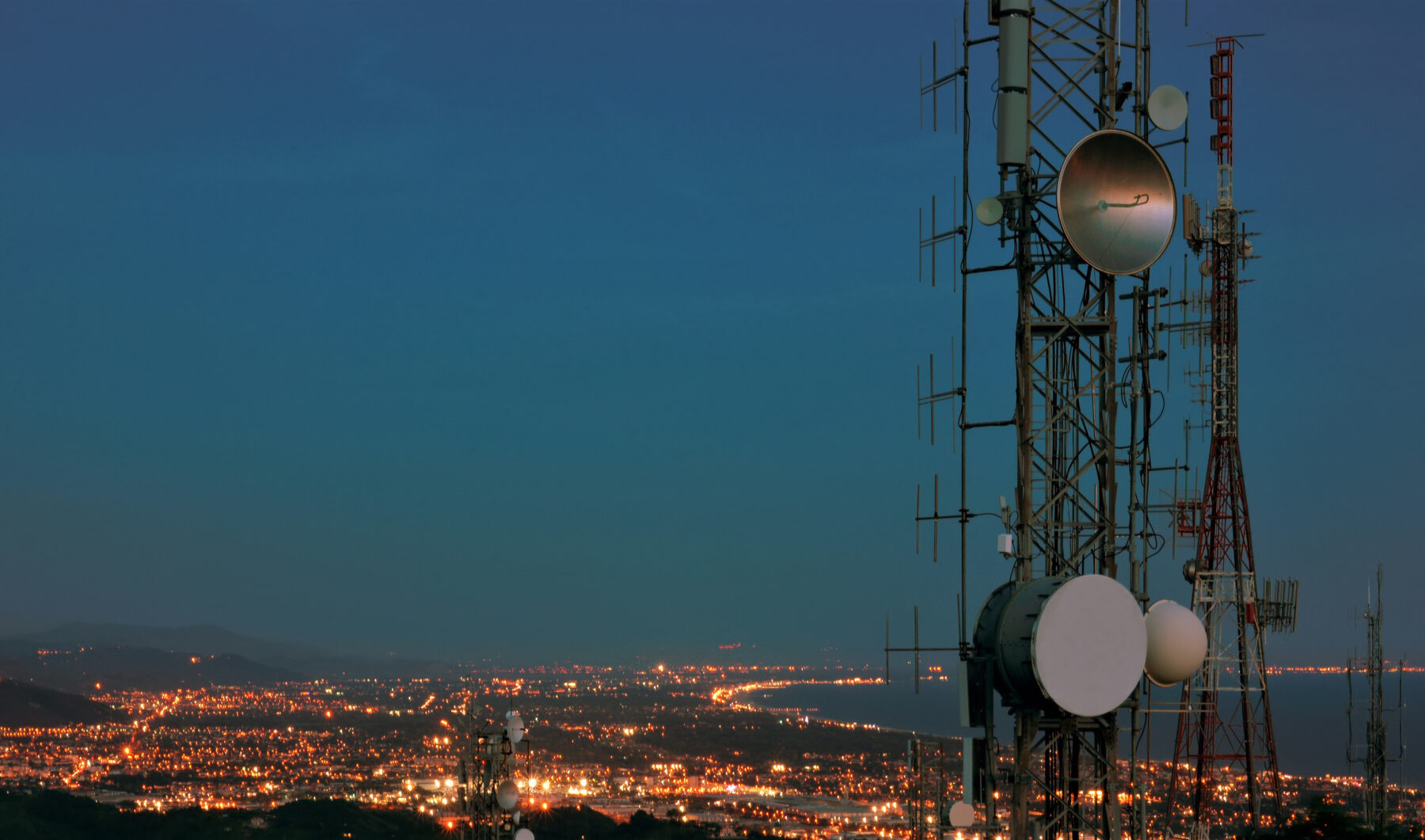 Telecommunications tower, over a city in the evening light
